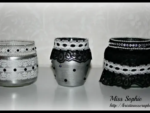 Three decorated glass jars with lace and beads.