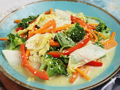 Buntes Gemüsegericht mit Chinakohl, Karotten, Brokkoli und Paprika in cremiger Sauce, bestreut mit Sesam. Leckere Chinakohl Rezepte!