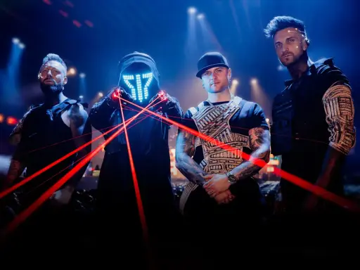 Medlemmar av Smash Into Pieces poserar med röda laserstrålar framför en mörk bakgrund med blå ljus.