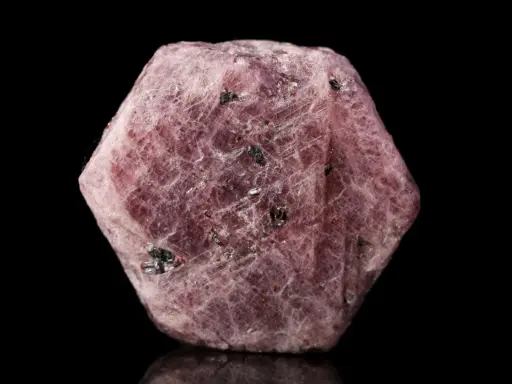 Cristallo grezzo di corindone rosa, con inclusioni scure. Il corindone, con il suo significato di forza e passione, si presenta in questa forma naturale.