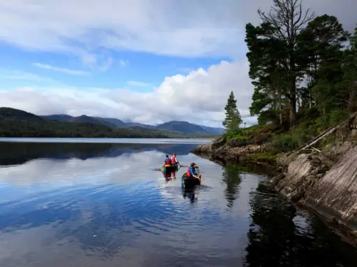 Zwei Kanus auf dem Loch Ness, umgeben von schottischen Highlands. Vielleicht sucht Nessie nach Gesellschaft?