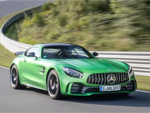 Grüner Mercedes-AMG GT R auf Rennstrecke, Fahrer im Fokus.