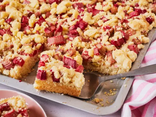 Saftiger Rhabarberkuchen mit Streuseln auf Hefeteig, frisch aus dem Blech geschnitten.