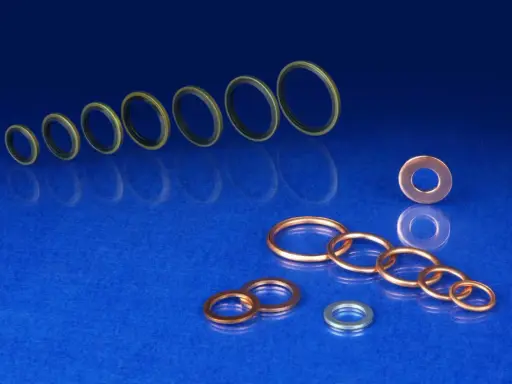 Variedad de arandelas de sellado de metal y goma, dispuestas en un fondo azul brillante.