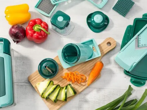 Ein nicer Dicer-Set mit verschiedenen Aufsätzen, Paprika, Zwiebel, Karotte und Zucchini. Perfekt für kreative Gemüsezubereitung.