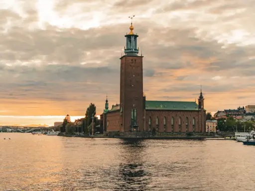 Stadshuset i Stockholm vid solnedgången. En vacker vy som inspirerar till roliga saker att göra i Stockholm, som en båttur eller promenad längs vattnet.