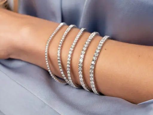 Bracciale tennis, un gioiello scintillante che ricorda la linea di un campo da gioco, indossato su un braccio.