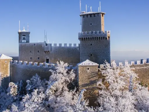 Le tre torri di San Marino innevate, un magico **percorso 3 torri San Marino** sotto un cielo azzurro.