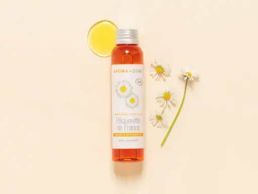 Flacon d'huile de pâquerette Aroma-Zone, avec des pâquerettes. Attention, l'huile de pâquerette danger potentiel pour certaines peaux.