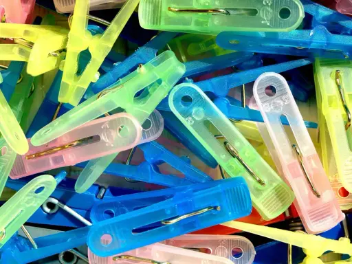 Kolorowe spinacze do prania, idealne do domowych sposobów czyszczenia plastiku.