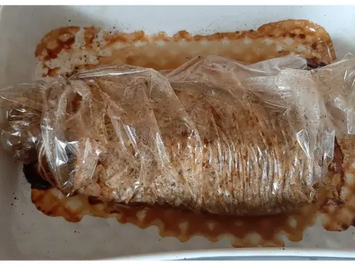 Schab pieczony w rękawie, soczysty i aromatyczny, w naczyniu żaroodpornym z wytopionym tłuszczem.