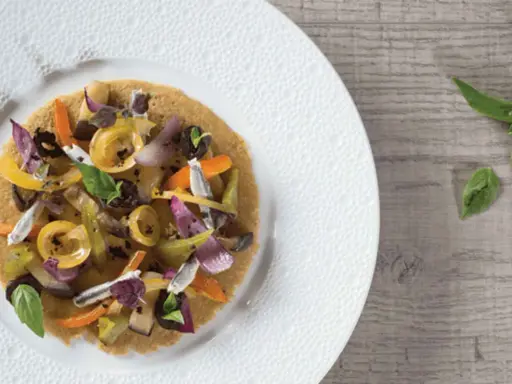 Socca garnie de légumes colorés et d'anchois, une idée pour votre recette socca.