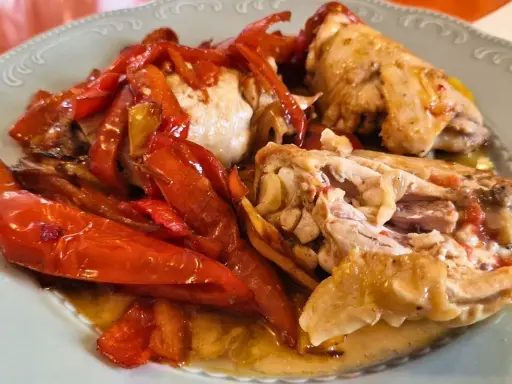 Pollo alla romana succulento con peperoni rossi arrostiti, un piatto saporito e invitante.