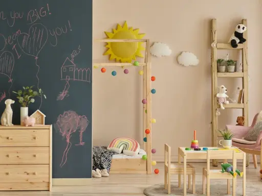 Ein gemütliches Montessori Kinderzimmer für 5-Jährige mit Tafelwand, Holzmöbeln, Spielzeug und einer Leiter als Regal.