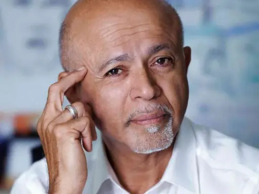 Ritratto di Abraham Verghese, con la mano sulla tempia, pensieroso.