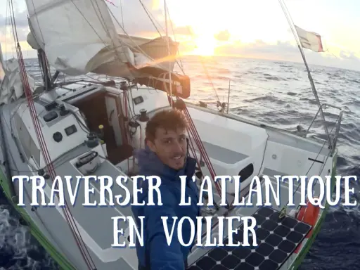 Un homme souriant sur un voilier navigue sur l'océan au coucher du soleil. Quel bateau pour traverser l'Atlantique ? Ce voilier semble prêt pour l'aventure.