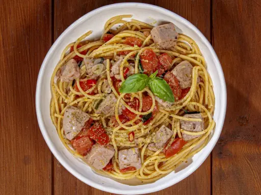 Spaghetti al tonno, un classico profumato, come la spaghetti al tonno ricetta della nonna, con pomodorini e basilico fresco.