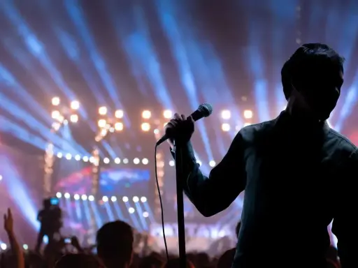Cantante sul palco con microfono, luci sfocate e folla. Il **take on me significato** è l'essenza di un'esibizione che cattura l'anima.