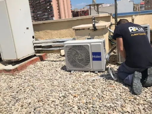 Técnico realizando mantenimiento preventivo de aire acondicionado en una azotea.