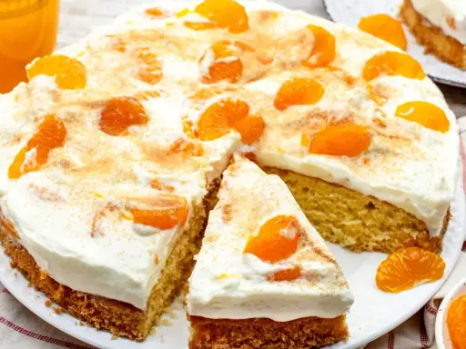 Ein saftiger Fantakuchen, perfekt als Tassenrezept, mit viel Sahne und Mandarinenstücken bestreut.