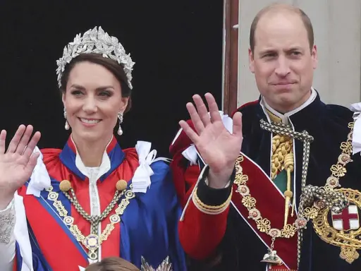 Kate Middleton och Prins William, medlemmar av brittiska kungahuset, vinkar från en balkong i sina högtidliga dräkter och juveler.