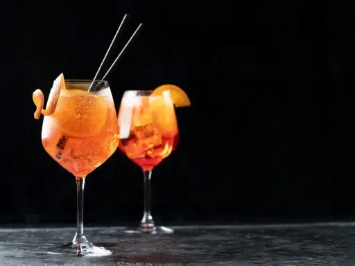 Zwei Aperol Spritz Gläser mit Orangenscheibe und Zitrusschale, perfekt für das Aperol Spritz Rezept in ml.