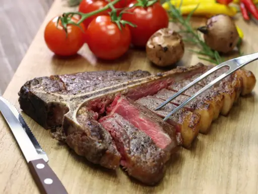 Una succulenta bistecca alla fiorentina, tagliata e pronta per essere gustata. Perfetta per scoprire dove mangiare la fiorentina a Firenze.