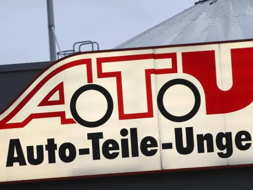 Leuchtreklame von A.T.U. Auto-Teile-Unger mit rotem Schriftzug und weißem Hintergrund.