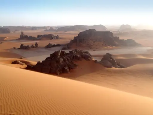 Sanddünen und Felsformationen in der algerischen Kulturlandschaft der Sahara. Ein Ort, der Geschichten von Nomaden und alten Zivilisationen erzählt.
