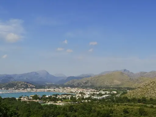 Vista panoramica del porto di Maiorca con montagne sullo sfondo e un mare pieno di barche.