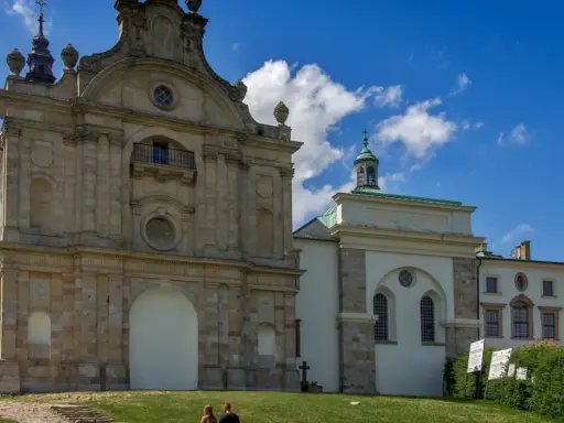 Barokowy zespół klasztorny na Świętym Krzyżu na Łysej Górze, z charakterystyczną architekturą i błękitnym niebem.