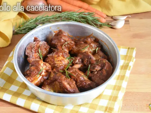 Succulento pollo alla cacciatora in padella, con rosmarino fresco e contorni di carote e aglio.