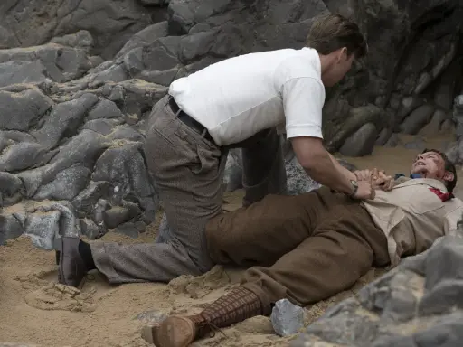 Un uomo a terra, ferito, mentre un altro cerca di aiutarlo. Chissà perché non l'hanno chiesto a Evans.