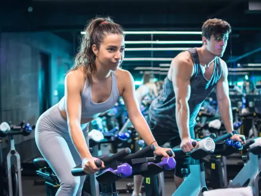 Para ćwiczy cardio na rowerze w siłowni.