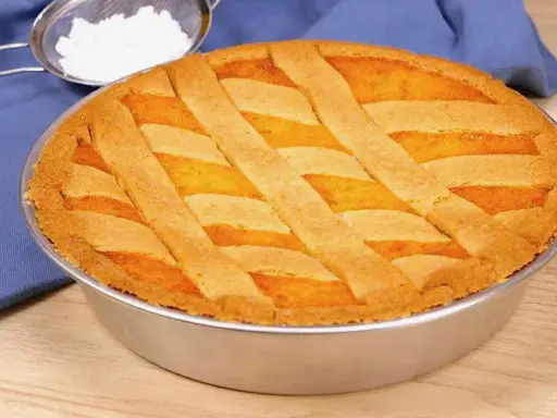 Pastiera napoletana ricetta originale: una torta dorata con decorazione a griglia, pronta per essere gustata.