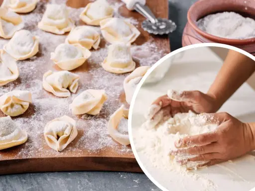 Ręce mieszają mąkę, przygotowując ciasto na pierogi. Na desce leżą gotowe pierożki, posypane mąką.