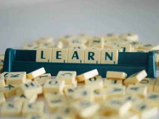 Litery na kafelkach układają się w słowo LEARN, symbolizując naukę i rozwijanie słownictwa. To świetny przykład na word formation C1.
