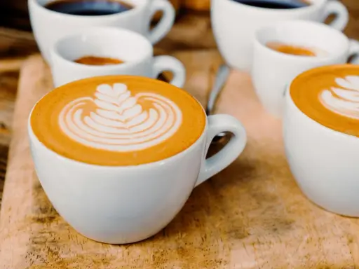 Kaffee-Kunst: Ein Cortado und ein Flat White, die sich in ihrer Zubereitung unterscheiden, aber beide mit Latte Art verziert sind.