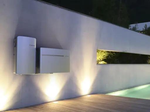 Två moderna batterienheter för solceller monterade på en vägg. Frågan om hur stort batteri till solceller behövs besvaras av dessa enheter.