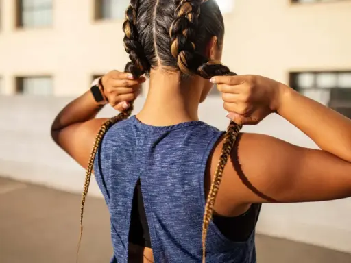 Frauen flechten Boxer Braids für ein sportliches Outfit.