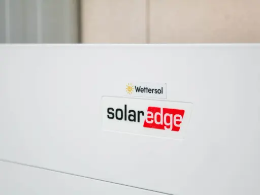 En vit enhet med logotyper för Wetter sol och solaredge optimerare.