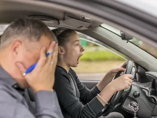 Instructor desesperado mientras una joven conductora, con cara de sorpresa, intenta sacarse el carnet de coche.