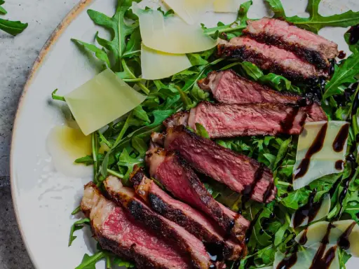 En saftig tagliata på en bädd av rucola med parmesanflisor och balsamico. Ett perfekt tagliata recept för en snabb och lyxig middag.