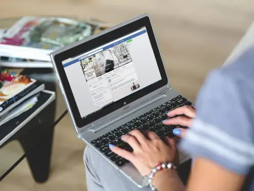 Kobieta pisze na laptopie, przeglądając stronę z inspiracjami wnętrzarskimi. To świetny post powitalny przykład dla nowych użytkowników.