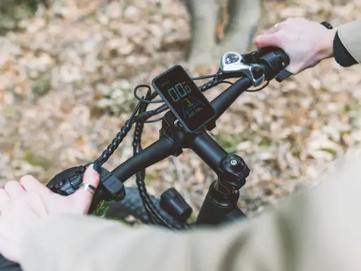Ręce na kierownicy roweru elektrycznego, wyświetlacz pokazuje prędkość. Ant+ co to za technologia?