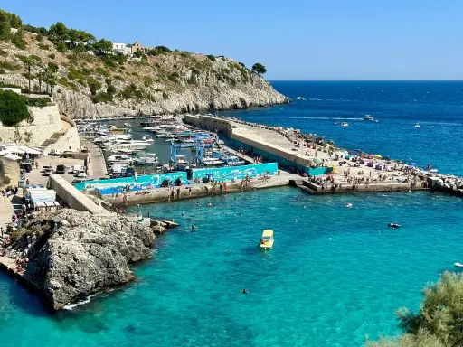 Un'estate a Castro: gente in spiaggia, barche nel porto e acque cristalline. Perfetto per scoprire cosa fare a Castro.