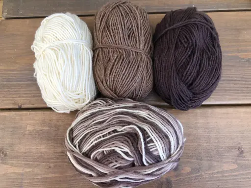 Garn i olika bruna nyanser och vitt, perfekt för att sticka varma drops syltasockor.