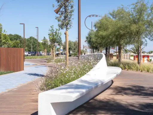 Passeggiata moderna con panchina bianca e fiori sulla bellariva di Rimini.