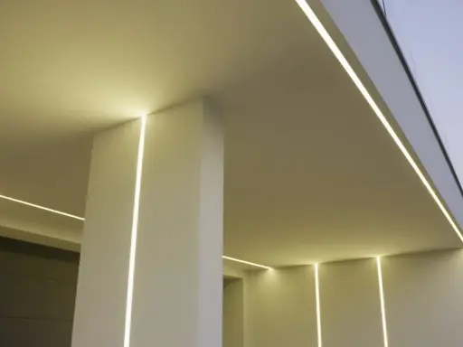Nowoczesny budynek z subtelnym oświetleniem. Wbudowany profil LED w ścianie tworzy eleganckie linie światła, podkreślając architekturę.