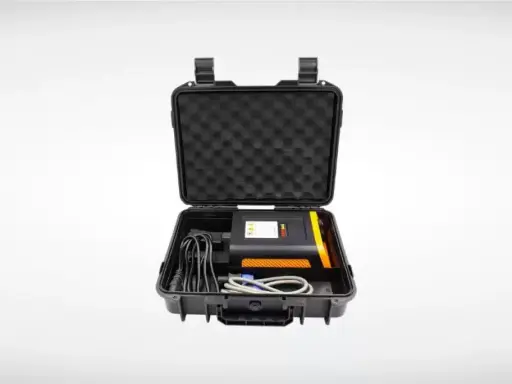 Estuche negro abierto con un dispositivo electrónico negro y naranja, cables y espuma protectora. Ideal para un sacabollos profesional.